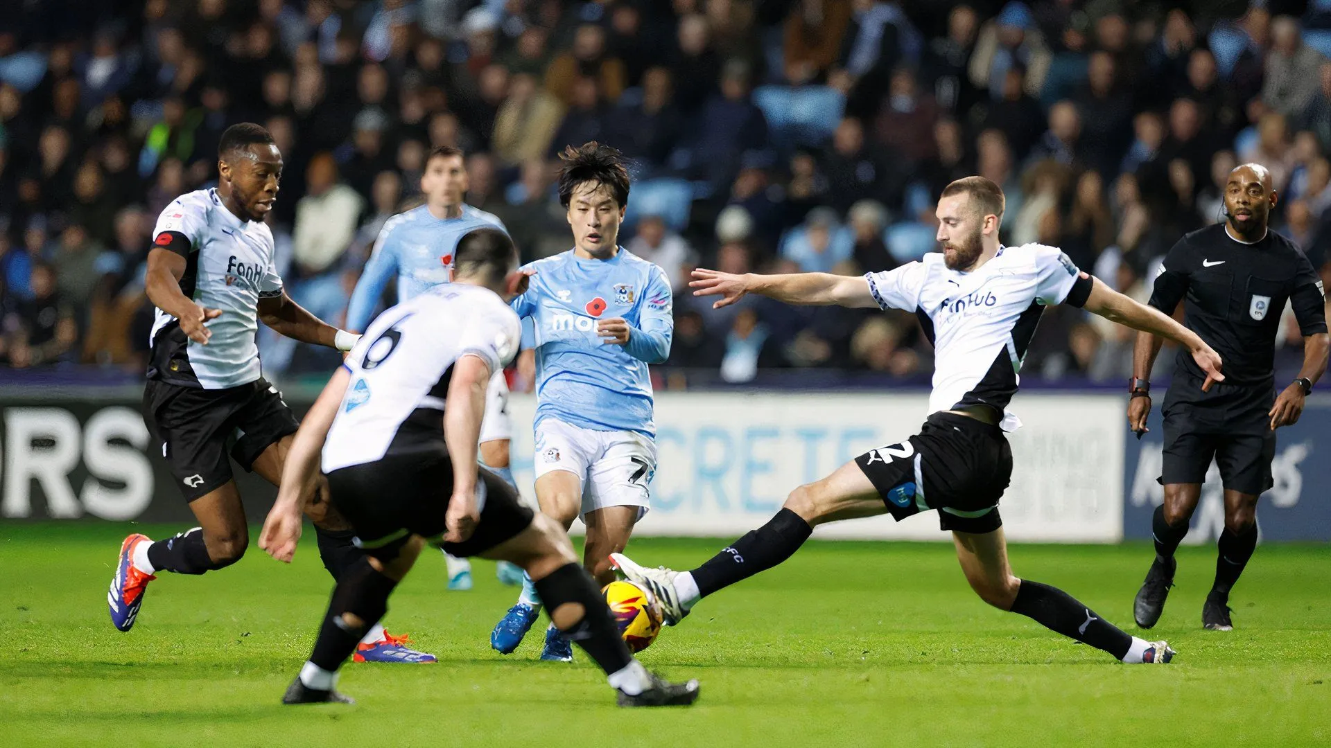 Tiền vệ Ebou Adams (trái) của Derby County quyết liệt trong pha tranh chấp với Tatsuhiro Sakamoto của Coventry City, với sự theo sát của đồng đội Nathaniel Phillips.